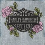 Hellblaue Harley Davidson Damen Jeansjacke mit Taschen an der Vorderseite und einem gestickten Rosenmotiv auf der Rückseite